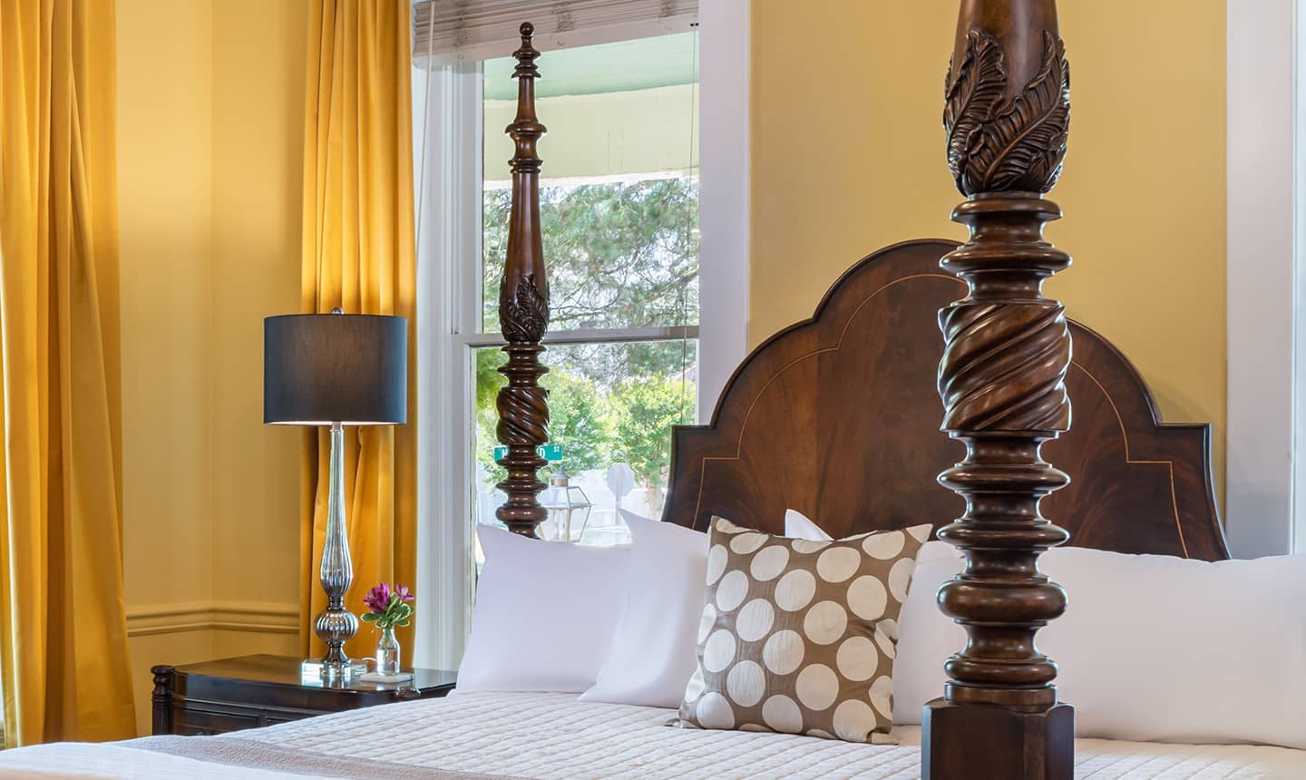 Closeup of bed and nightstand in Hugh Williamson Suite