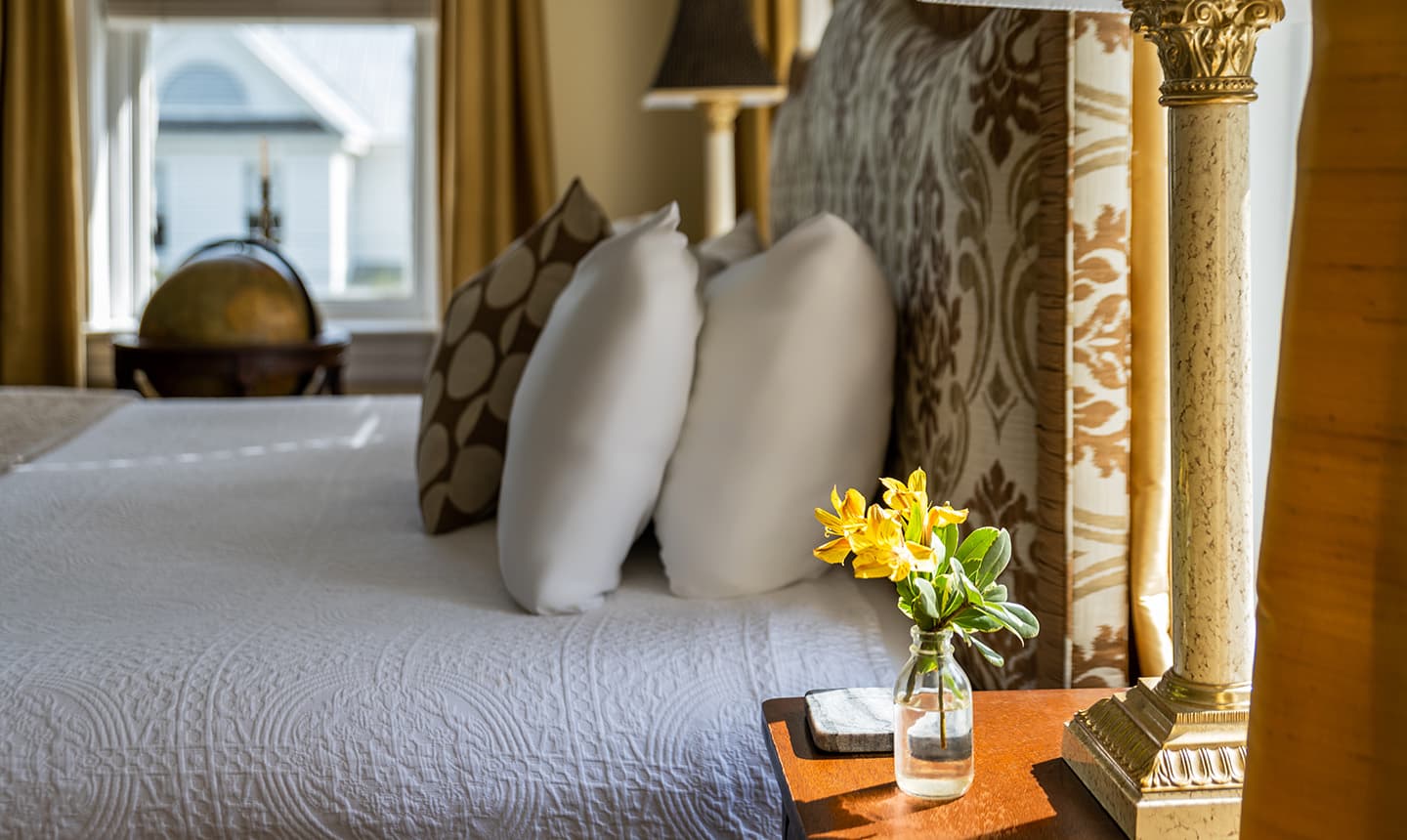 Closeup of pillows and nightstand in Inglis Fletcher Room