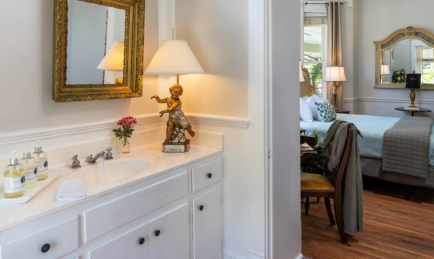 Bathroom vanity and view to room in Penelope Barker Suite