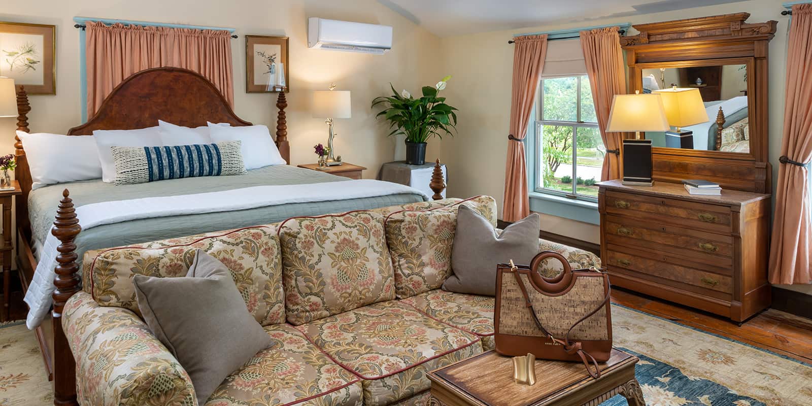 Bed and Couch in Sandy Point Suite with travel bag