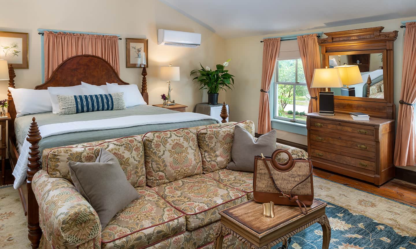 Bed and Couch in Sandy Point Suite with travel bag