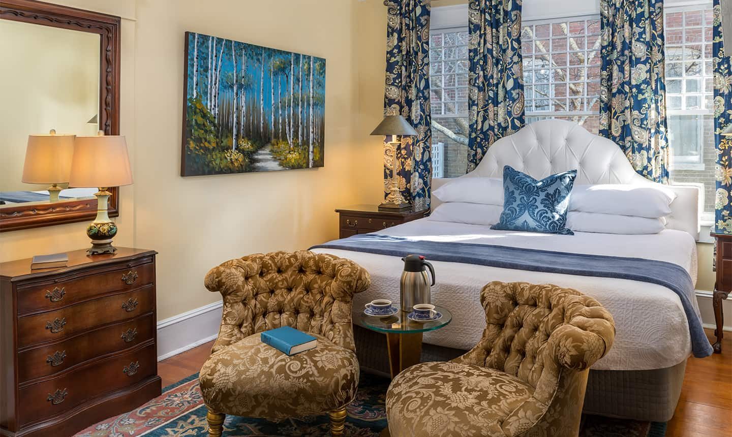 Bed with two chairs in Supering King Suite in Satterfield House