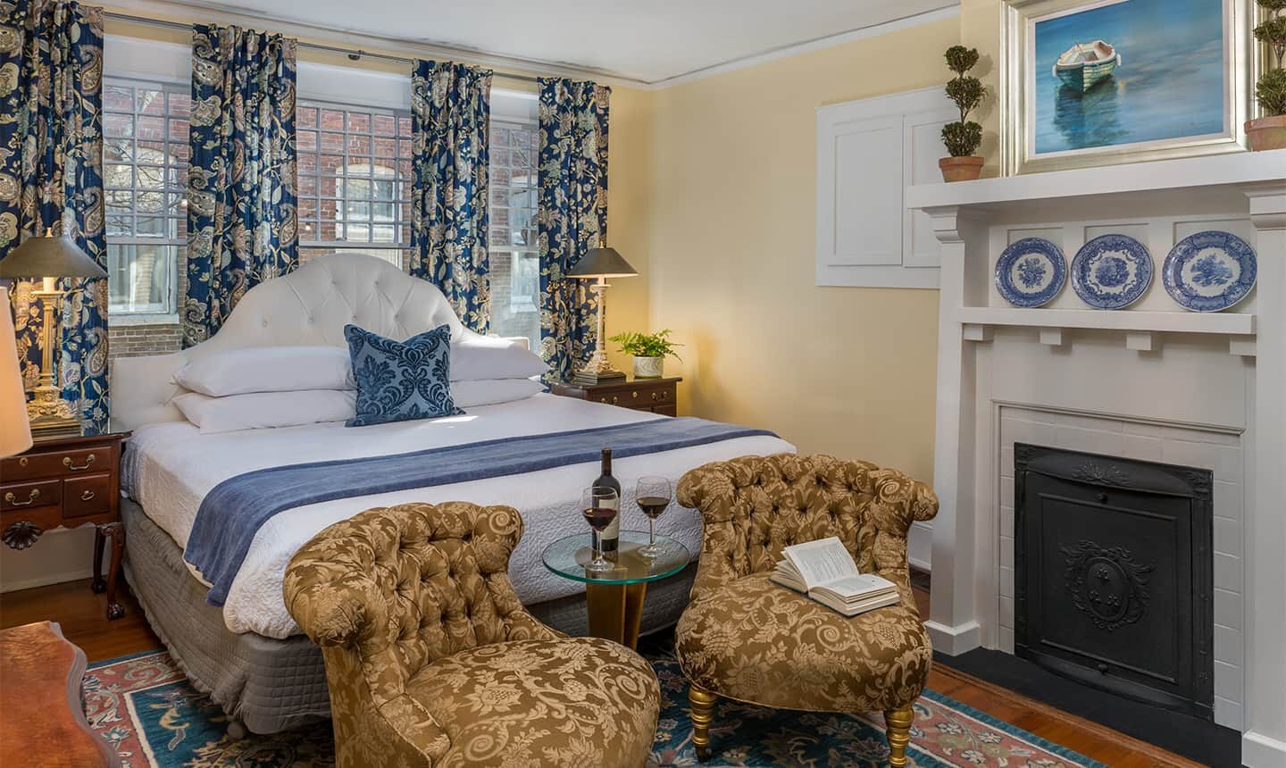 Bed with two chairsf and fireplace in Supering King Suite