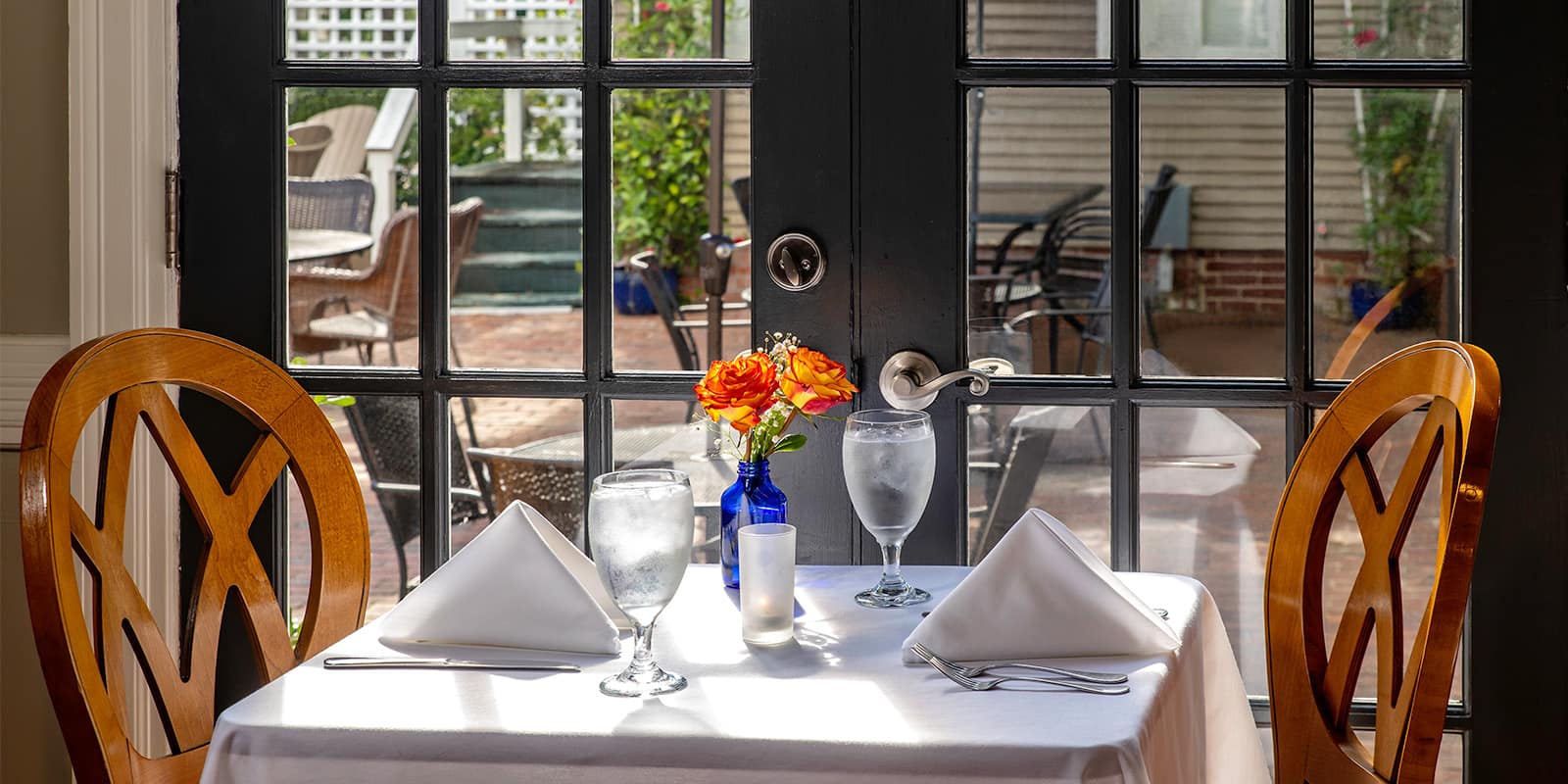 Table for two by the patio doors set for a meal