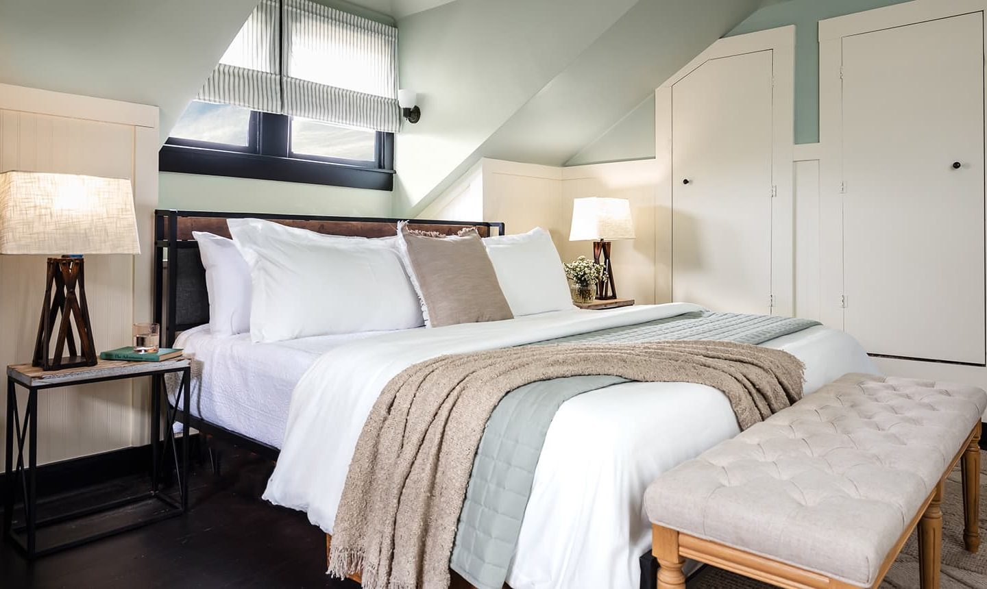 Bed, nightstands, and bench in The Loft Suite