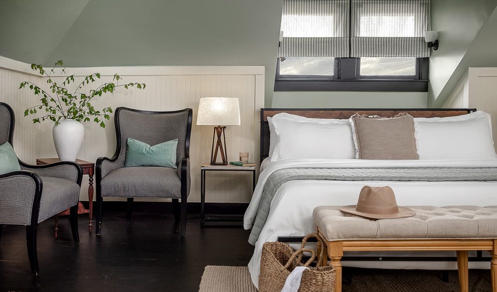 Bed, nightstand, and chairs in The Loft Suite