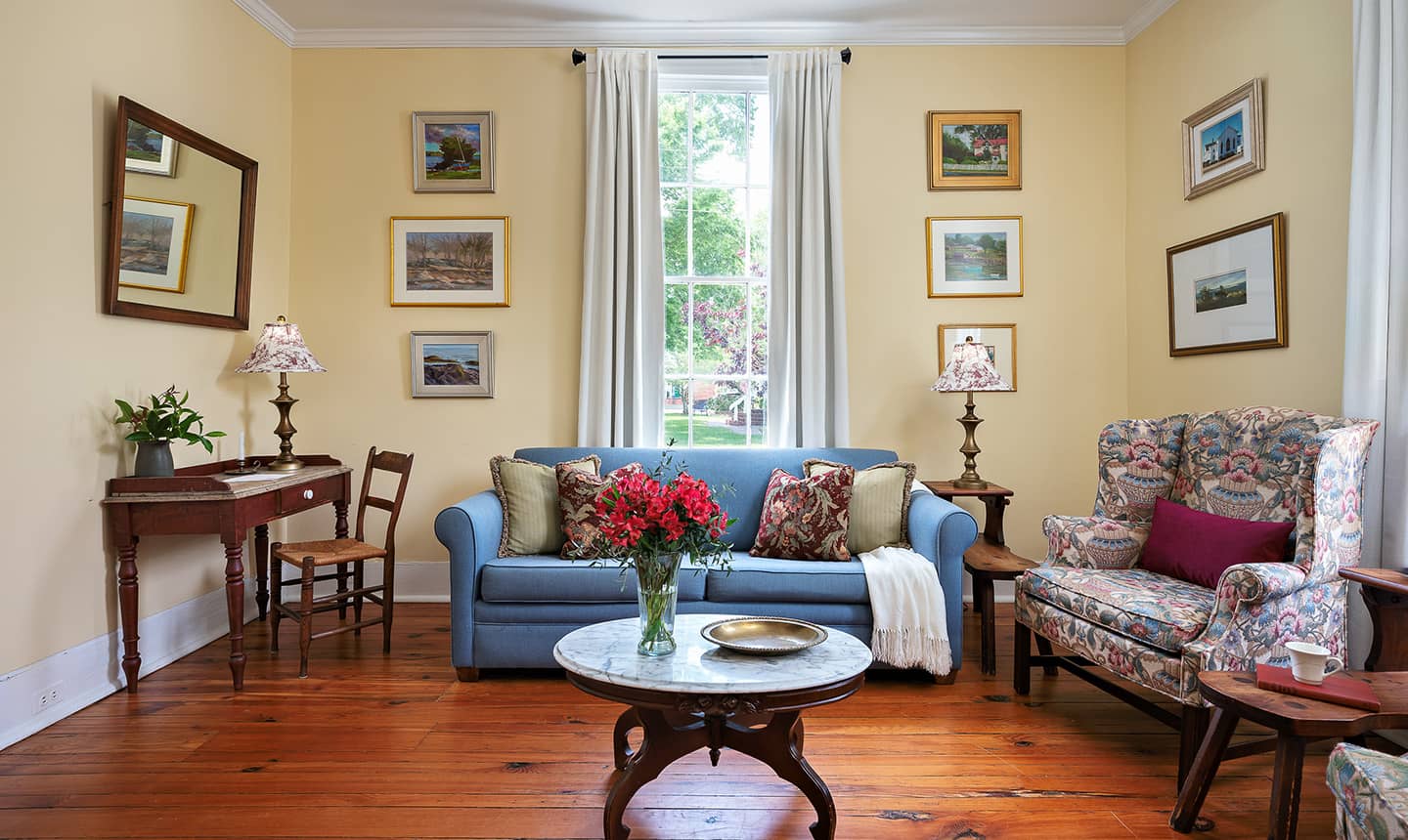 Living area with couch, desk, and chair in Tillie Bond Suite