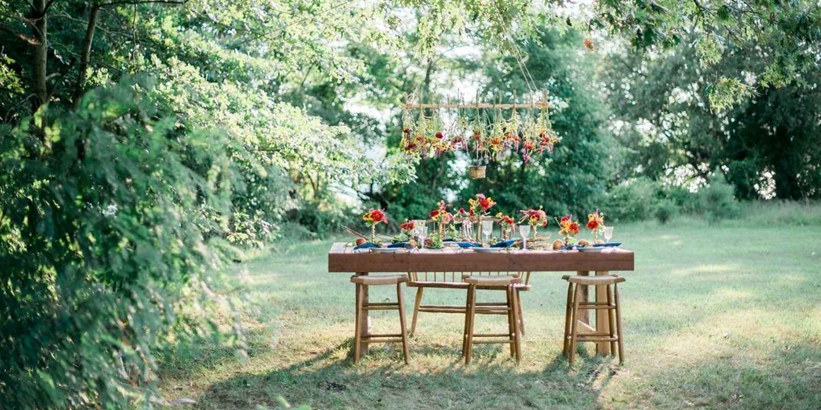 Outdoor ining table set up for a wedding in North Carolina with roses hanging above it