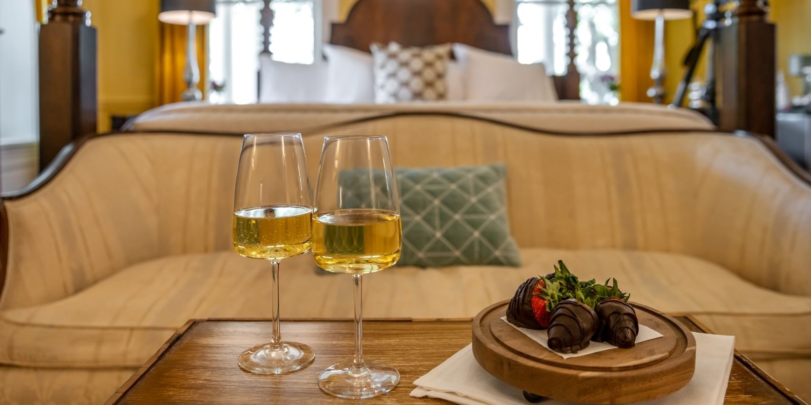 Glasses of white wine and chocolate covered strawberries on the coffee table in a suite at Inner Banks Inn