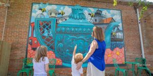A mother and her two children admiring a mural in Edenton, NC