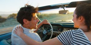 A happy couple driving a convertible car on a romantic trip in NC