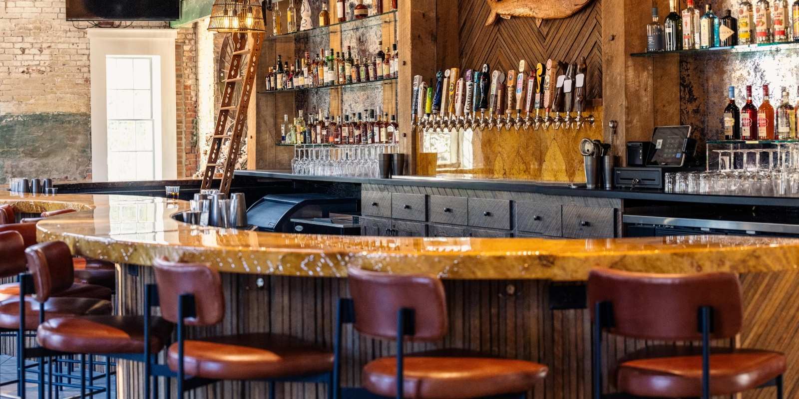 Bar stools at a wooden bar at The Herringbone restaurant in Edenton, NC