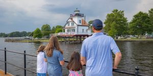 A family on vacation in North Carolina looking at the Roanoke River lighthouse in Edenton.